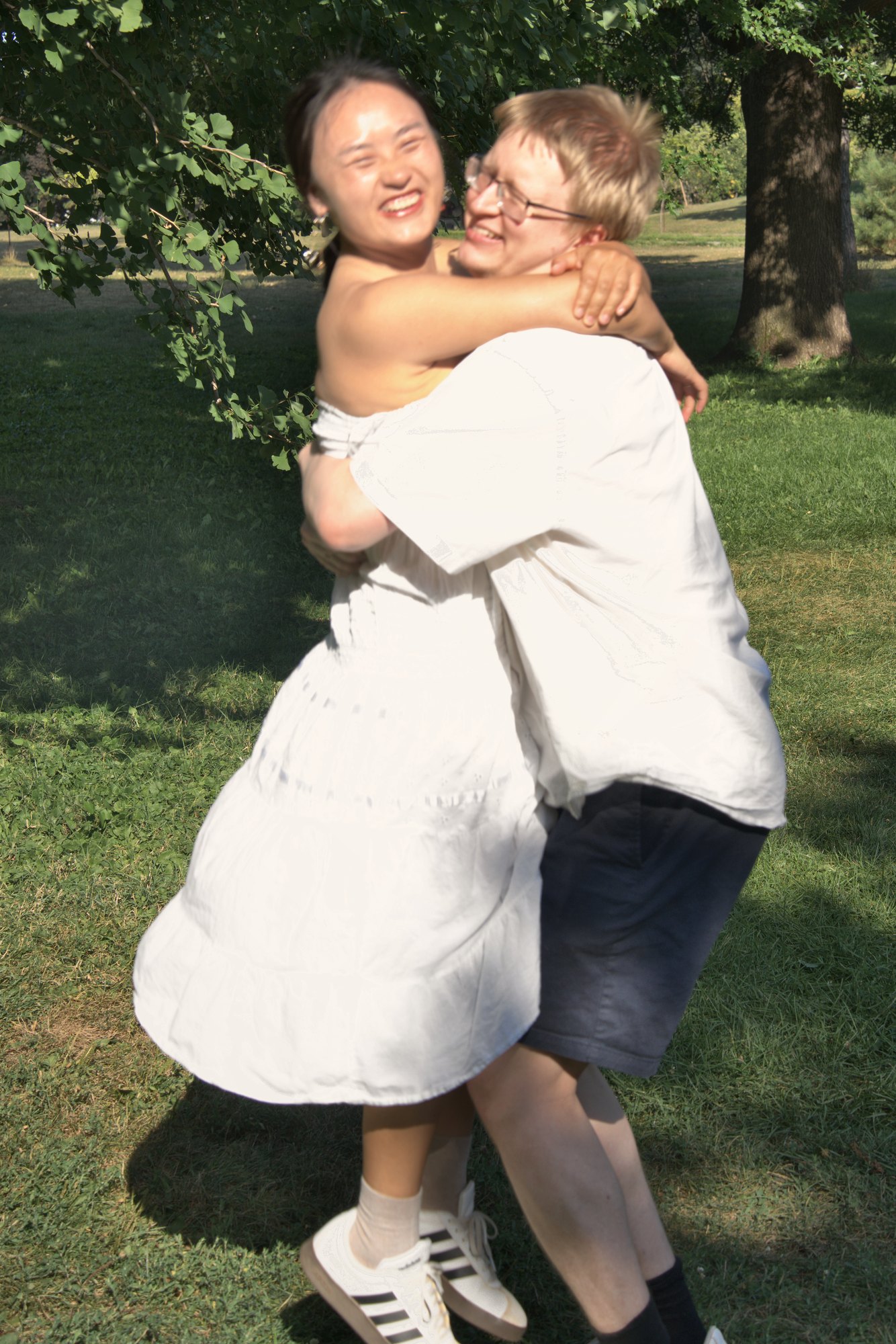 Couple laughing as he lifts her off the ground in a summer park — Twin Cities couples and engagement photography by Loon & Birch Photography