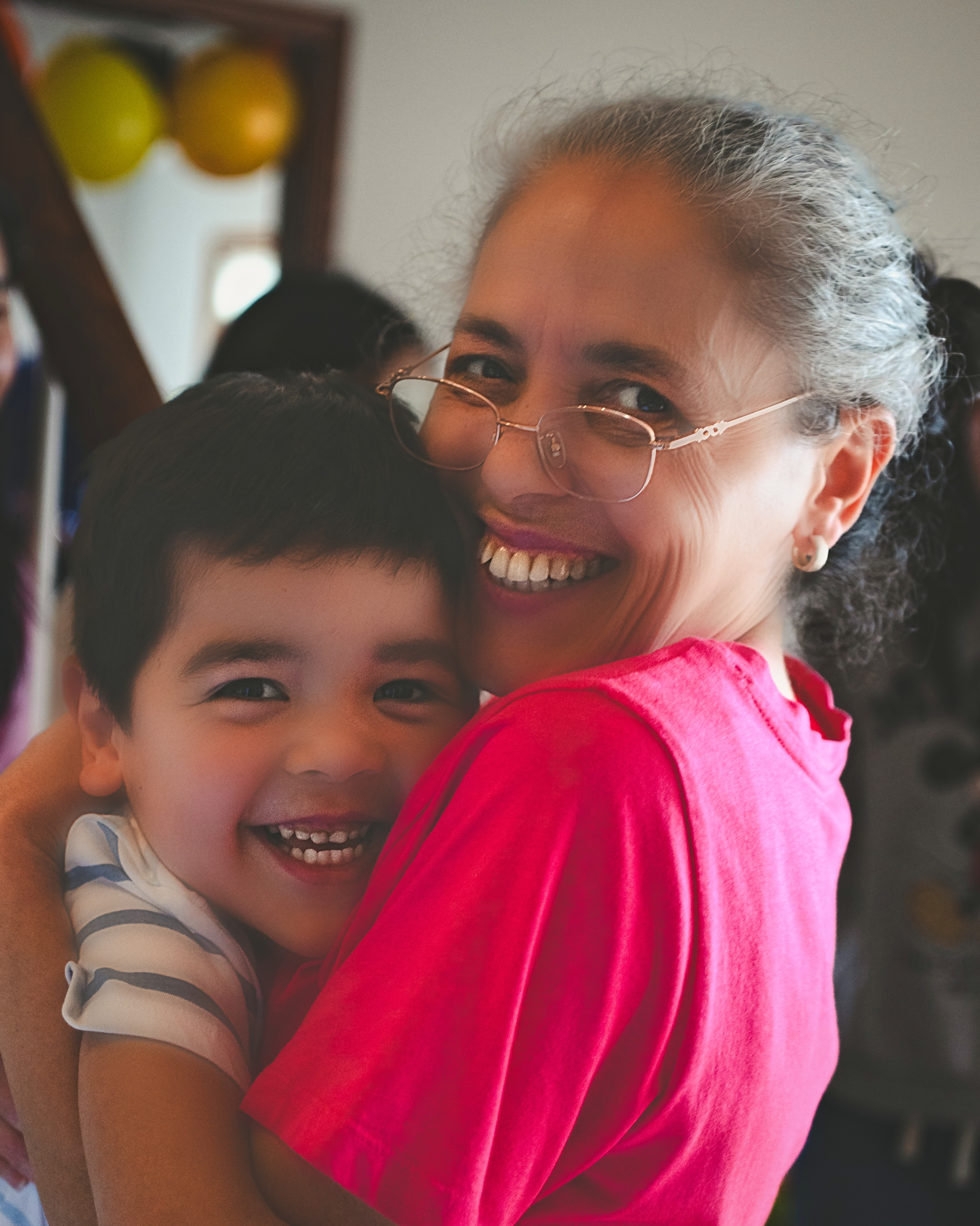 Grandmother and grandson laughing cheek to cheek at a family celebration — Twin Cities family photography by Loon & Birch Photography
