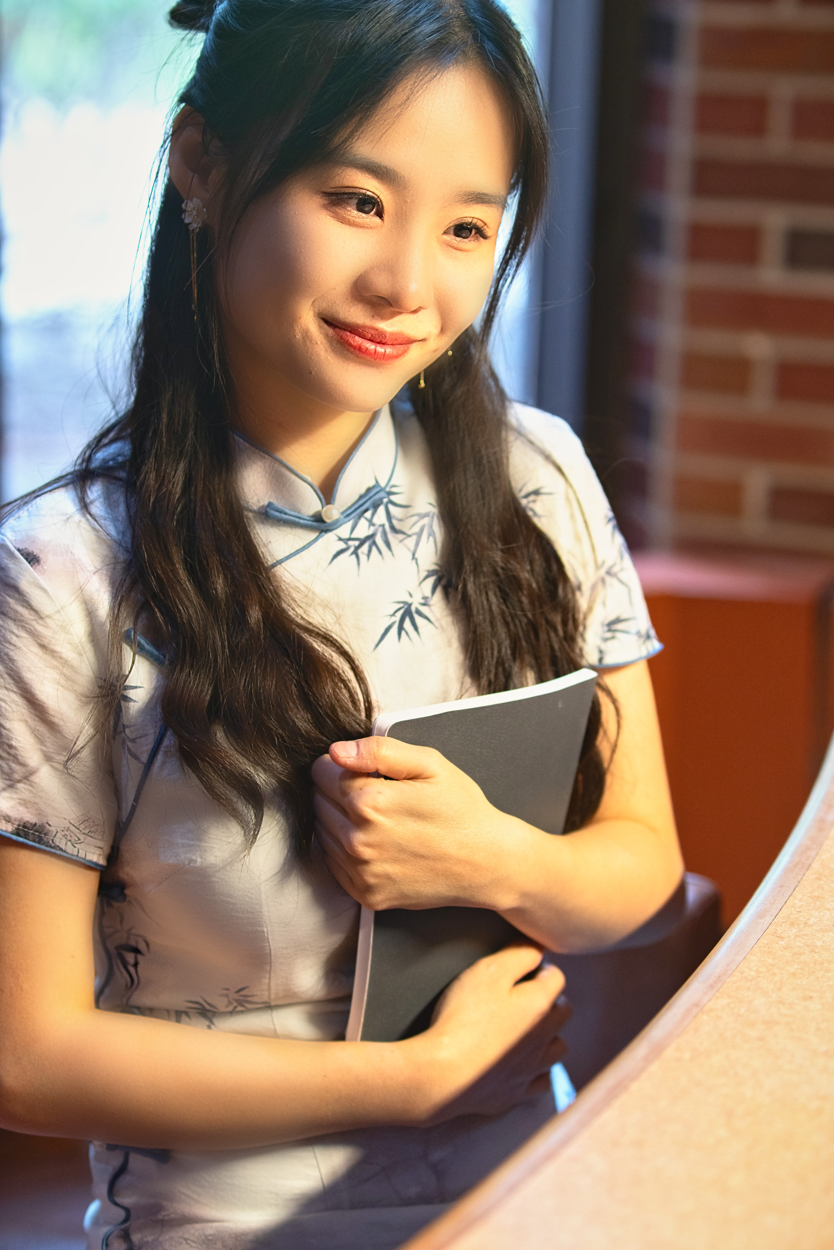 Young woman holding a notebook in warm side light — Twin Cities event and senior portrait photography by Loon & Birch Photography