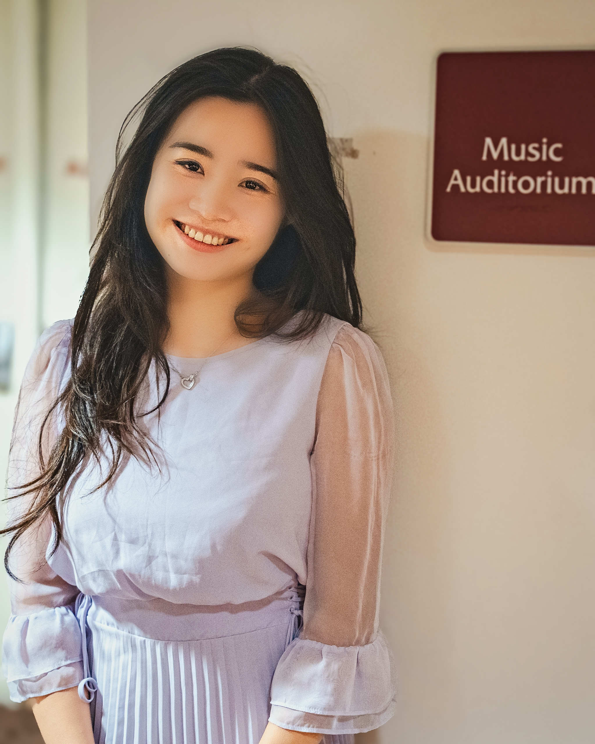 Senior portrait of a smiling young woman outside a music auditorium — Twin Cities event and senior portrait photography by Loon & Birch Photography