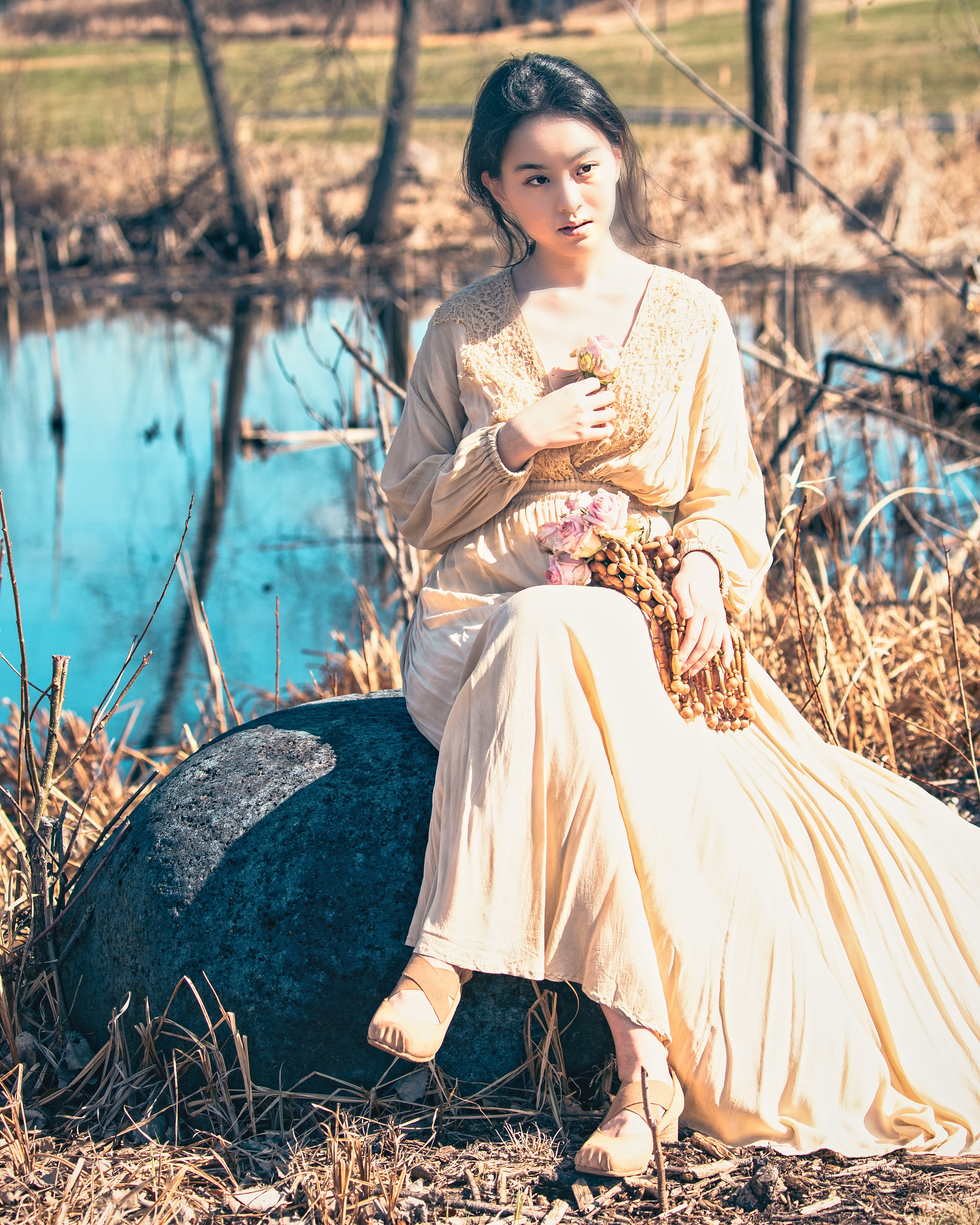 Young woman in a flowing dress seated by a pond — Twin Cities event and senior portrait photography by Loon & Birch Photography